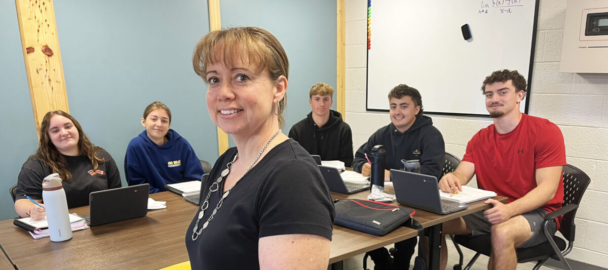 Principal Jessica Vanderbrook stands in font of her class of students.