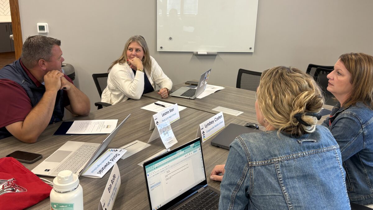 4 ILN participants sit at a table discussing