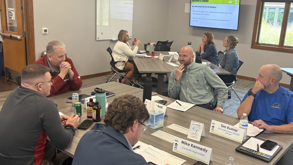 5 ILN participants sit at a table discussing