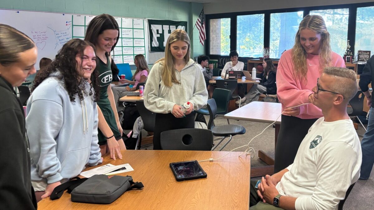 Forest Hills Central students demonstrate a hands-on activity with their school leader.