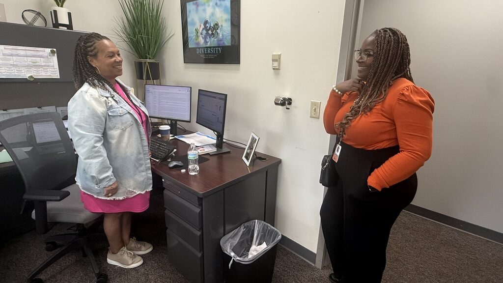 Administrator and Attendance Coach talking in an office