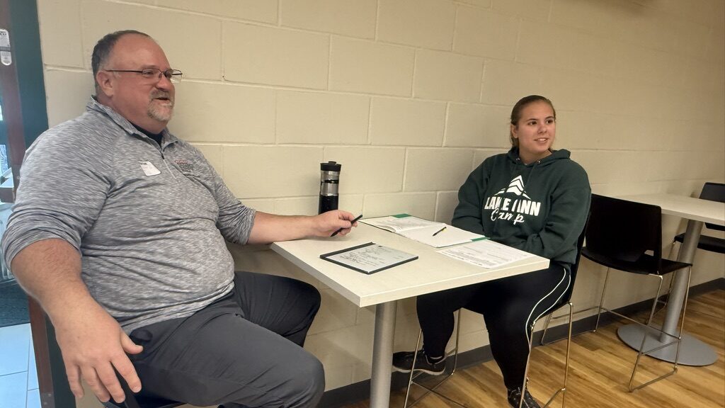 Professional mentor sits at a table with a student