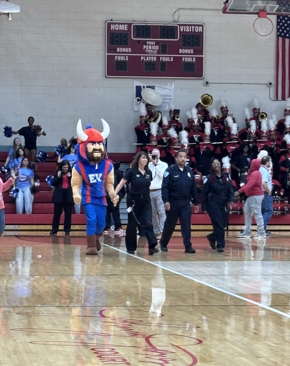 Amy Boyles walking into the Gymnasium filled with students, staff and guests.
