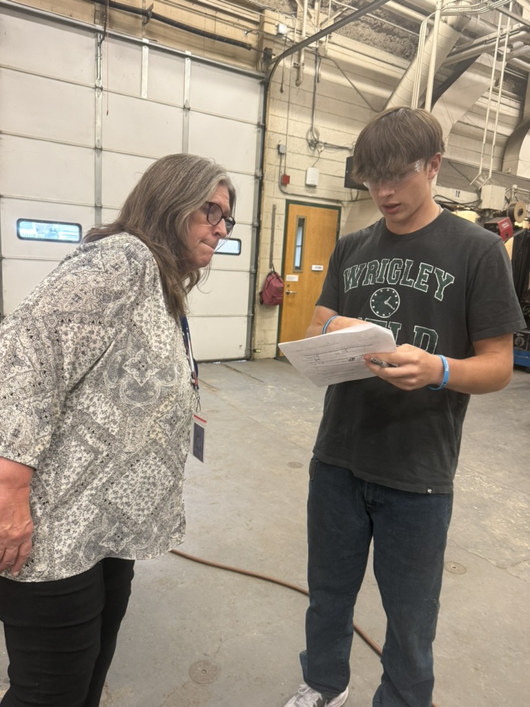 Teacher and student standing looking a paper