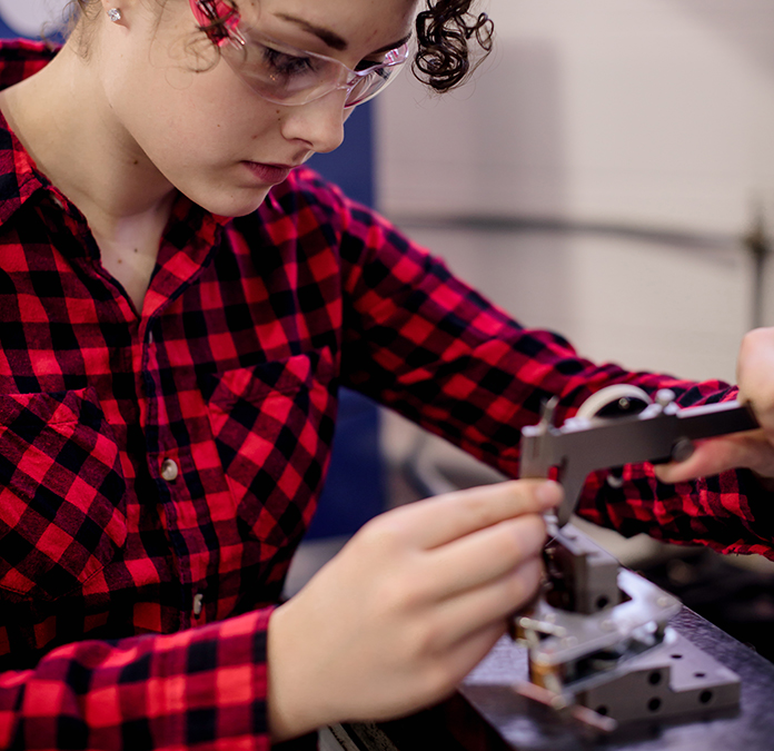 Student using a micrometer to measure a piece of metal