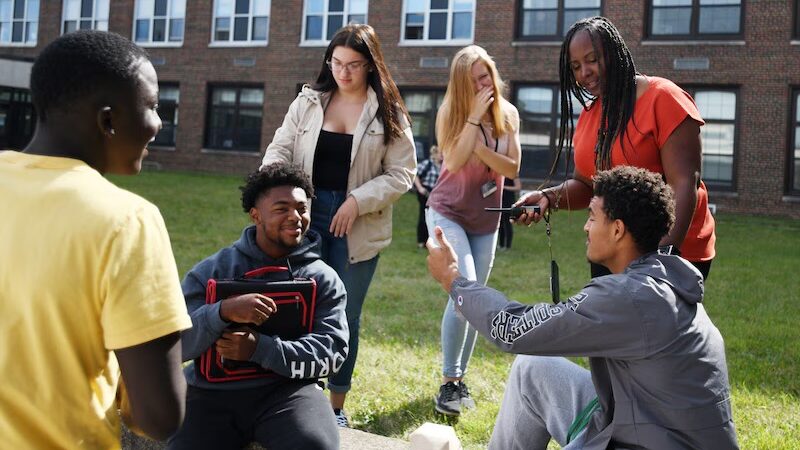 Administrator talking with a group of students outside